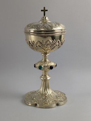 un calice en argent richement décoré, surmonté d'une croix