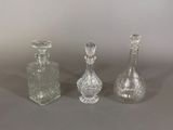 three clear glass bottles sitting next to each other on a table