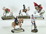 several figurines of people riding horses with flags on them