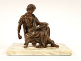 statue en bronze représentant une femme assise sur un socle en marbre, accompagnée d'un chien