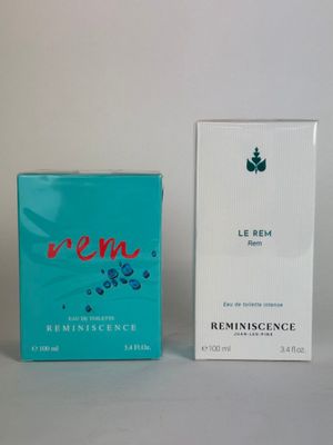 two boxes of perfume sitting next to each other on a table