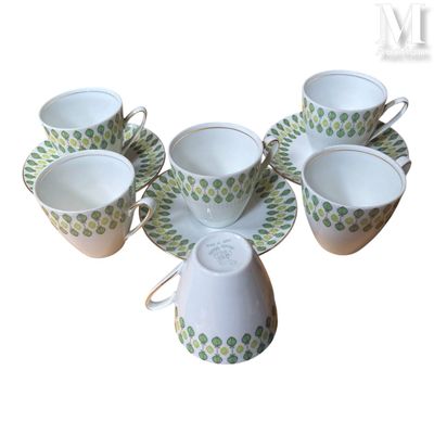 Plusieurs tasses et soucoupes sont disposées en cercle sur une surface blanche