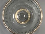 a glass bowl with a gold rim on a white surface