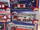 several different types of toy fire trucks in boxes on a table