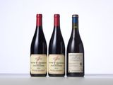 three bottles of wine are lined up on a table