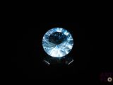 a close up of a blue diamond on a black surface