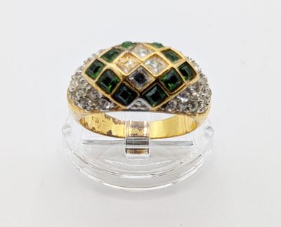 an image of a diamond and emerald ring on a clear surface