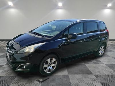 a black minivan parked in a garage with a checkered floor