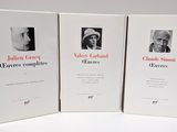 three books on a white table with a picture of a man and a woman