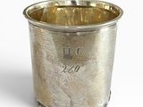 une tasse en argent posée sur une surface blanche