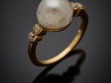 a white pearl and diamond ring on a black background