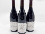 trois bouteilles de vin posées sur une table l'une à côté de l'autre