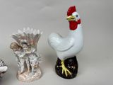 three figurines of a rooster and a chicken on a table