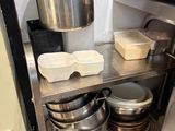a stainless steel shelf with pots and pans on it