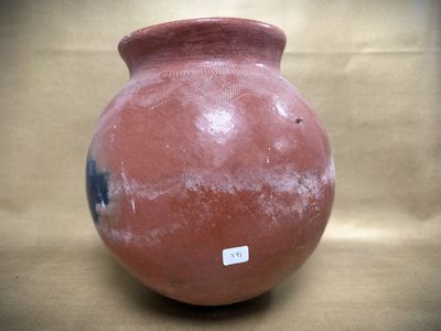 a red vase sitting on a table with a sticker on it