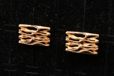 deux paires de boucles d'oreilles en or posées sur un fond de velours noir