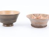 two small bowls sitting next to each other on a white surface