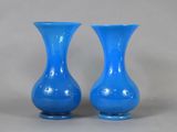 two blue vases sitting next to each other on a table