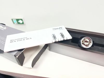 une montre en argent posée sur une boîte, elle-même posée sur un bureau