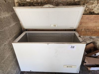 un congélateur à compartiment ouvert posé sur une pile de cartons