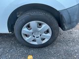 une petite voiture blanche avec un pneu crevé sur la route