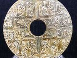 an image of a gold plate with designs on it on a black background