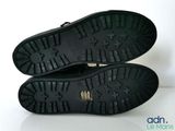 pair of black leather shoes with gold trims on a white surface