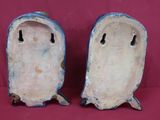 une paire de figurines en céramique bleues et blanches sur fond rouge
