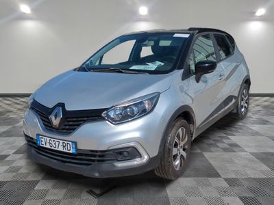 une voiture argentée garée dans une pièce au sol en damier
