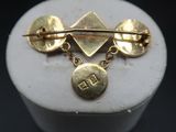 an image of a close up of a gold broochle on a mannequin