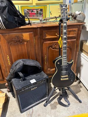 a guitar and amp sitting on the floor next to a cabinet