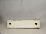 an old white plate with holes on it sitting on a table