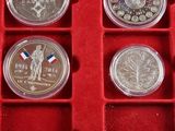 four different types of silver coins in a red display case