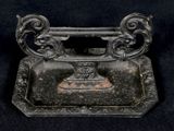 un petit objet métallique posé sur une surface noire