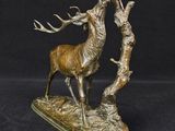 bronze sculpture of a stag with antlers on a black background