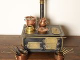 un poêle à l'ancienne sur lequel sont posés des casseroles et des poêles