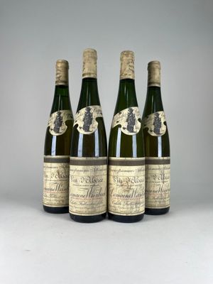 quatre bouteilles de vin sont alignées sur une table