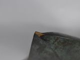 a close up of a metal object with a wooden stick sticking out of it