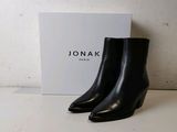 a close up of a pair of black ankle boots on a table