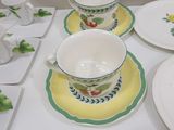 a white table topped with plates and cups and saucers