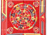 un foulard carré rouge et jaune orné d'un motif circulaire