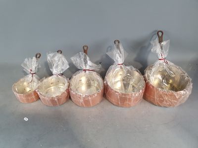 six petits bols de nourriture recouverts d'un film alimentaire, posés sur une table
