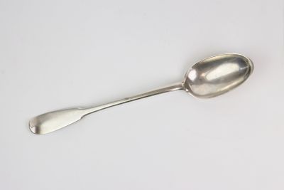 une cuillère en argent avec un manche de cuillère sur une surface blanche