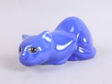 a blue cat figurine sitting on a white surface