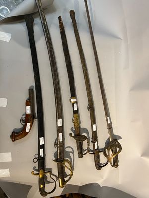 cinq types d'armes différents exposés dans une vitrine