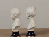 two statues of a boy and a girl on a table