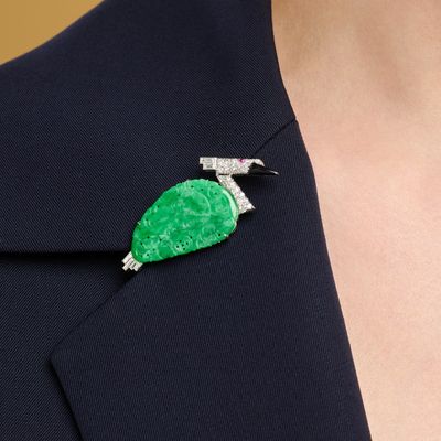 a close up of a woman wearing a green broocher
