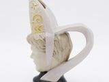 a ceramic head of a man with a hat on it