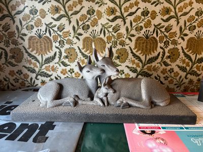 a statue of a dog and a cat laying on a pillow