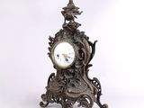 une horloge posée sur un support sur fond blanc